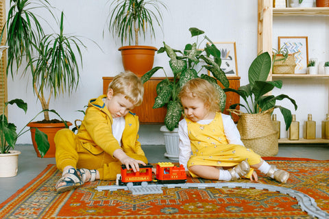 two children playing with train together - play development